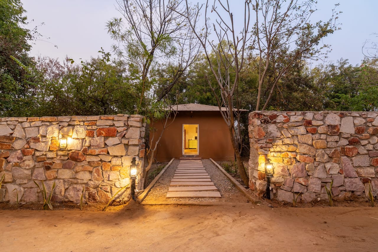 Stone entrance of Tiger Machan Resort at night