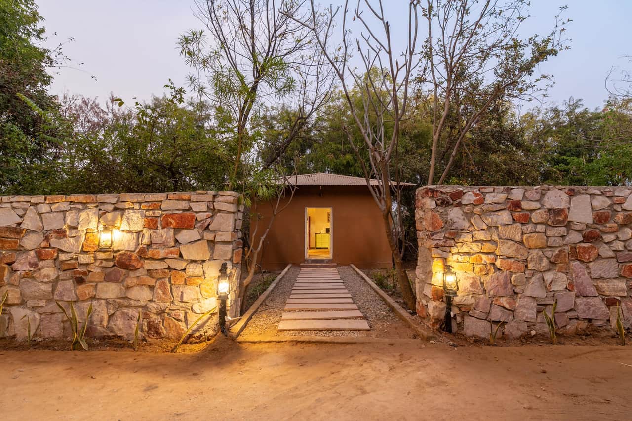 Stone entrance of Tiger Machan Resort at night