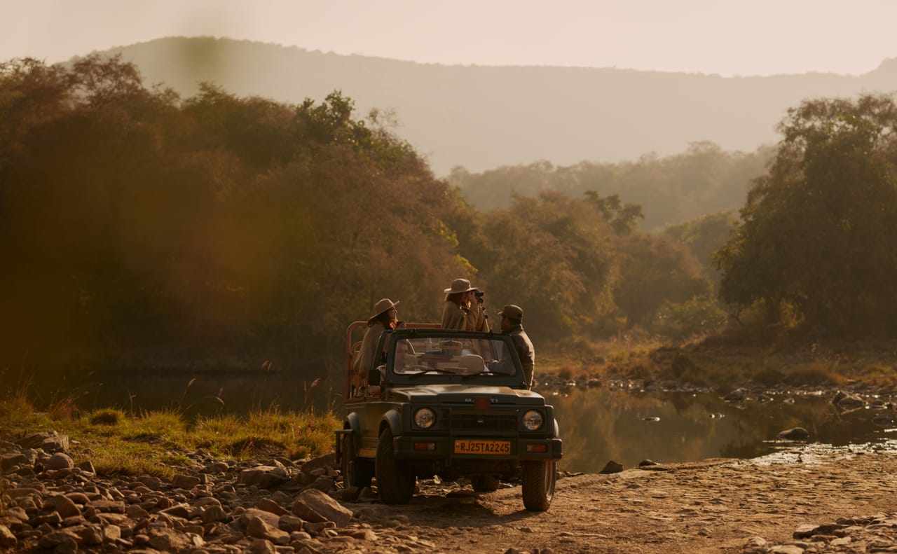 Safari jeep in a misty valley below the Aravalli hills